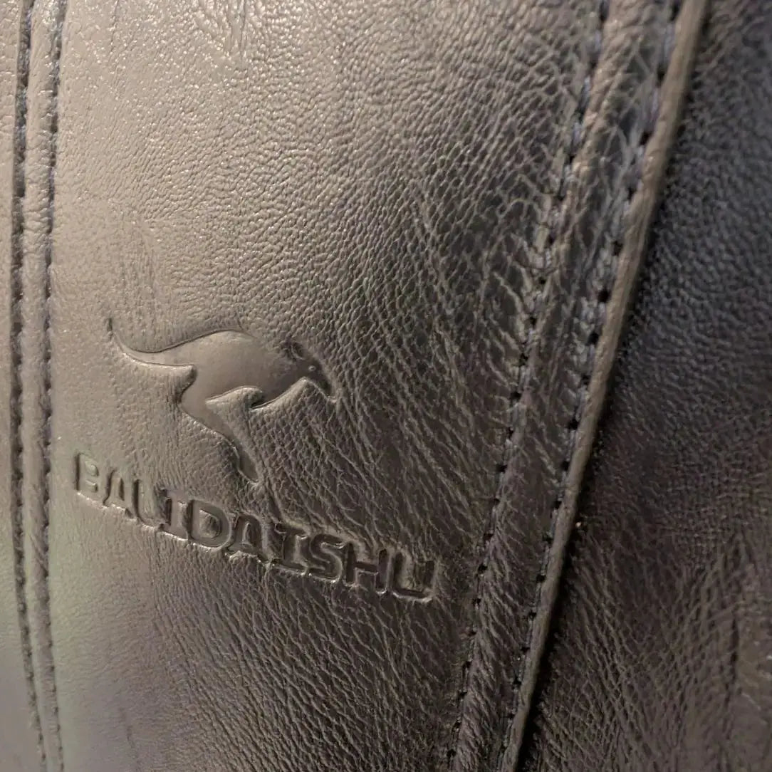 Détail du logo Olixya embossé sur le cuir du sac à dos femme noir, antivol et imperméable